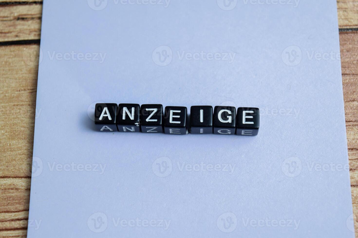 Concept of The wooden Cubes with the word Anzeige it means Advertisement on wooden background. German language isolated on Wooden Table. photo