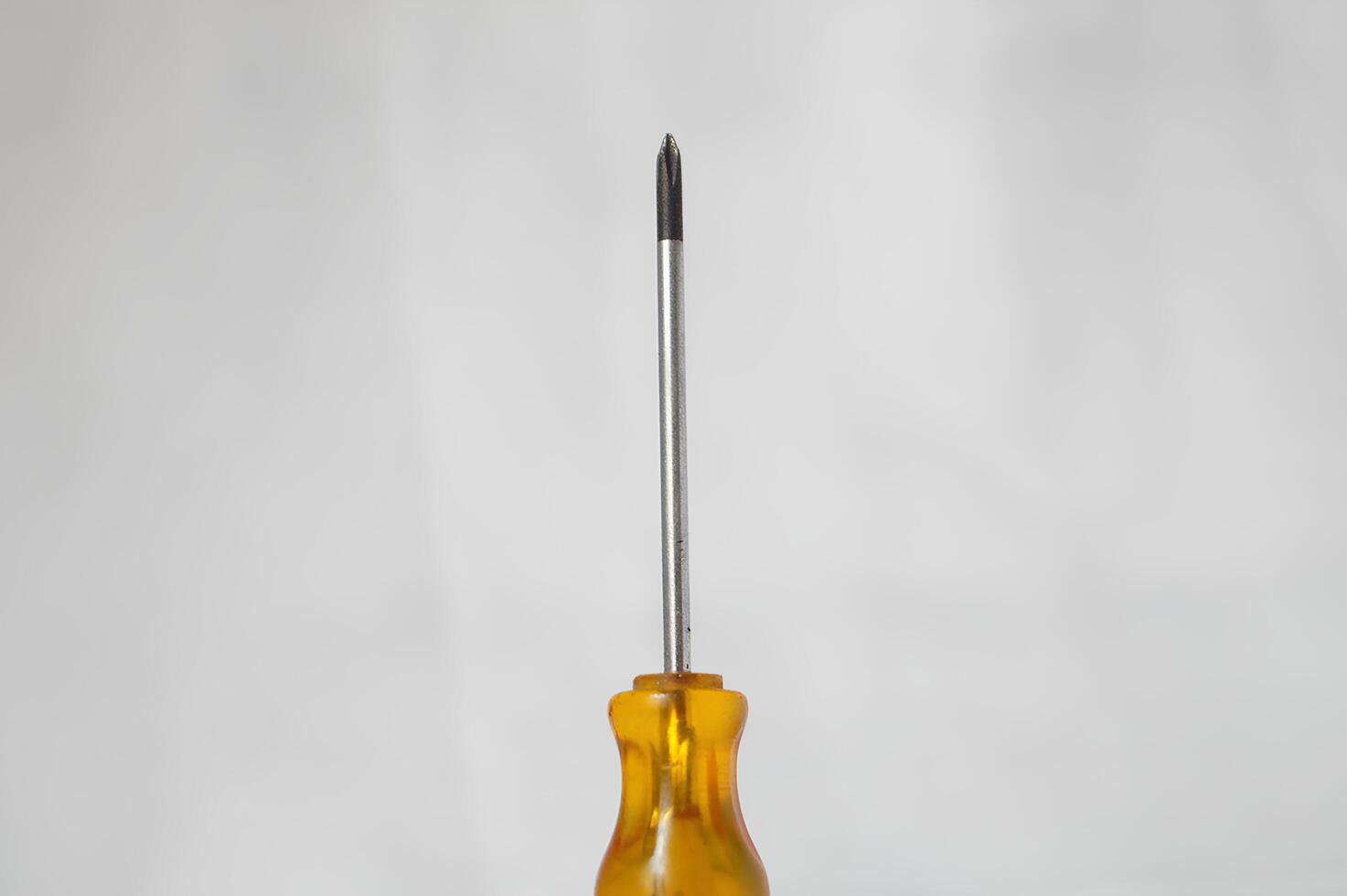 A yellow screwdriver with a silver tip photo