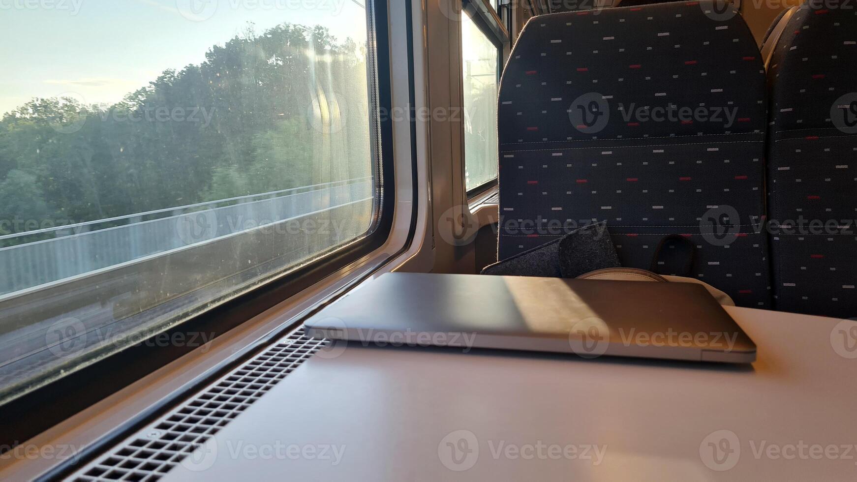 Working on the Go. Using a Laptop on a Train Journey with Scenic Views Outside the Window - Emphasizing Productive Travel and Efficient Transportation photo