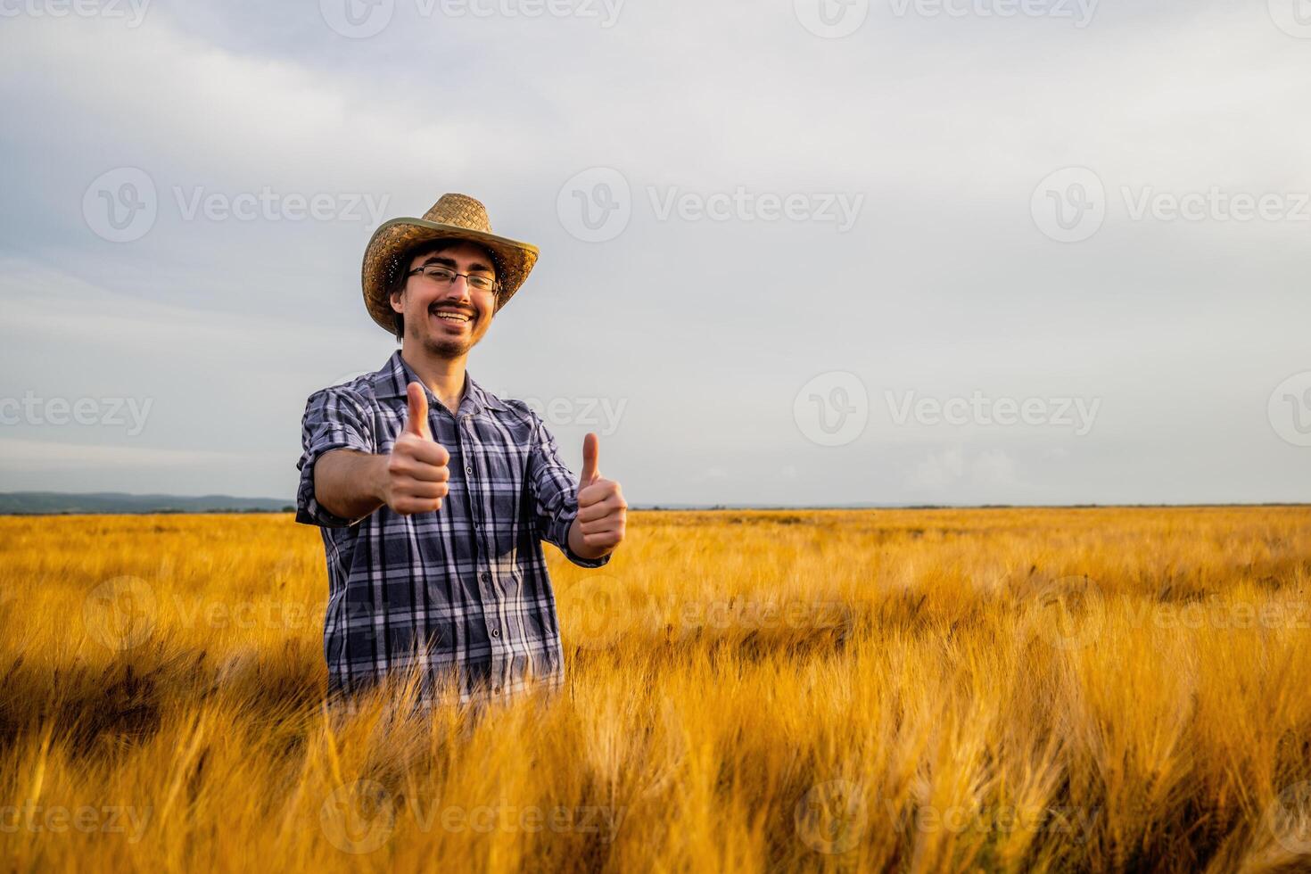 Portrait of happy farmer in his wheat field. He is satisfied with crops. photo