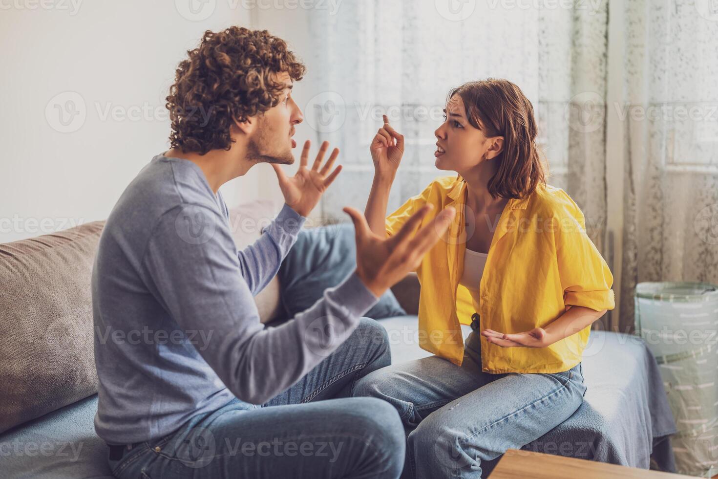 Man and woman are sitting at sofa and arguing. Relationship problems. photo