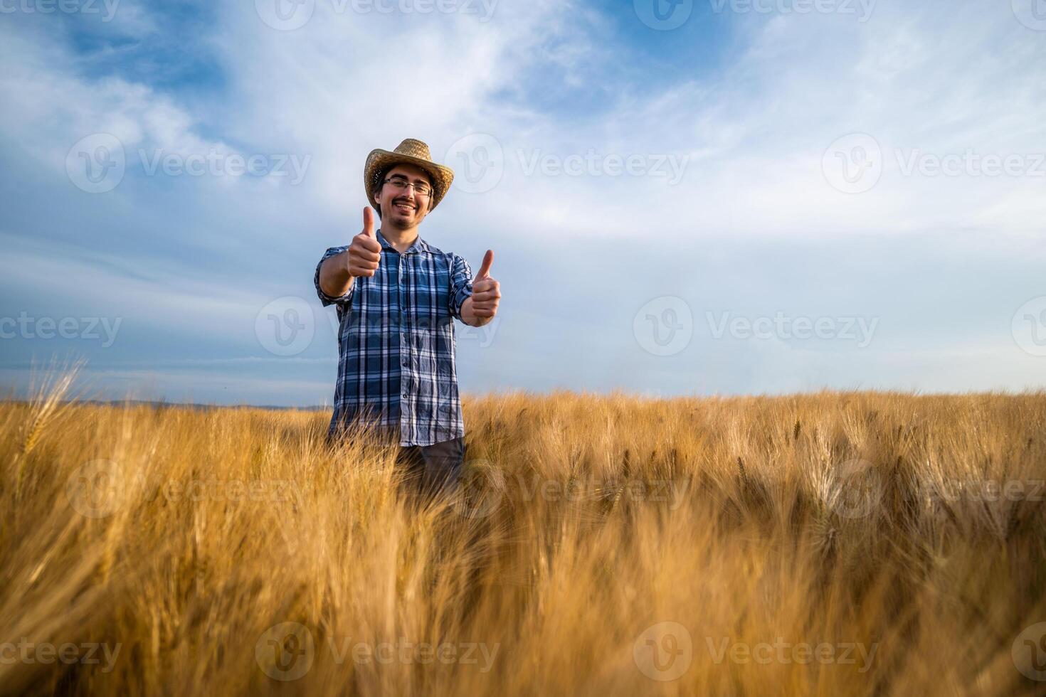 Portrait of happy farmer in his wheat field. He is satisfied with crops. photo