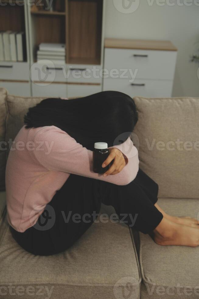 Depressed woman sitting alone on the bed with hands on head feel stress, sad and worried in the dark bedroom and low light environment photo
