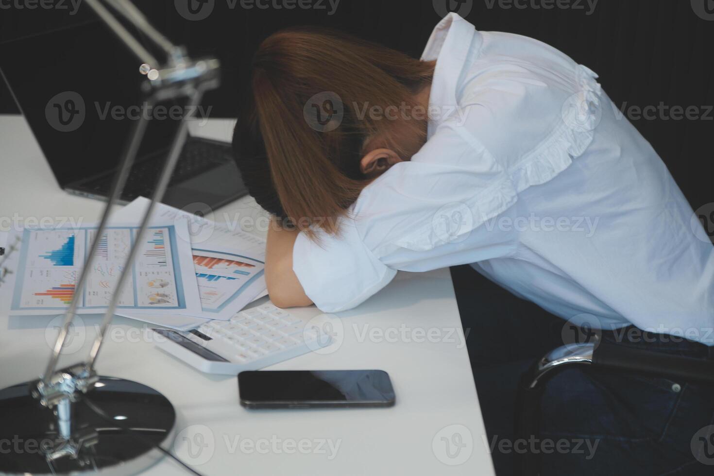 Businesswoman yawning while working with a laptop computer in the office, a woman in casual office lifestyle concept. photo