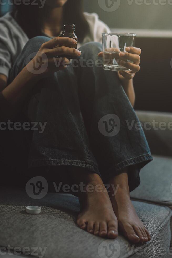 Upset woman frustrated by problem with work or relationships, sitting on couch, embracing knees, covered face in hand, feeling despair and anxiety, loneliness, having psychological trouble photo