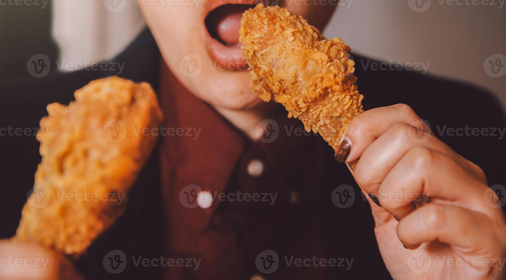 close up focus woman hand hold fried chicken for eat,girl with fast food concept photo