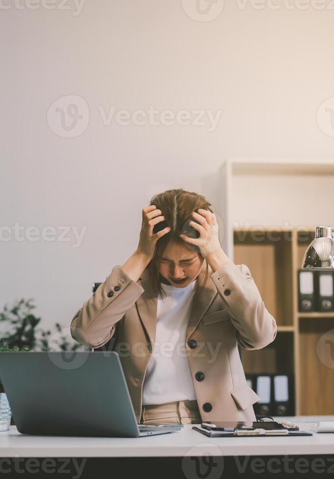 Asian women sitting in an office With stress and eye strain Tired, portrait of sad unhappy tired frustrated disappointed lady suffering from migraine sitting at the table, Sick worker concept photo