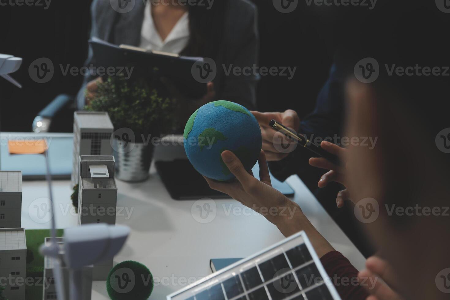 Business people having consultation about wind energy at company office. Business team discussing about windmill and alternative green energy. Executive meeting at modern office photo