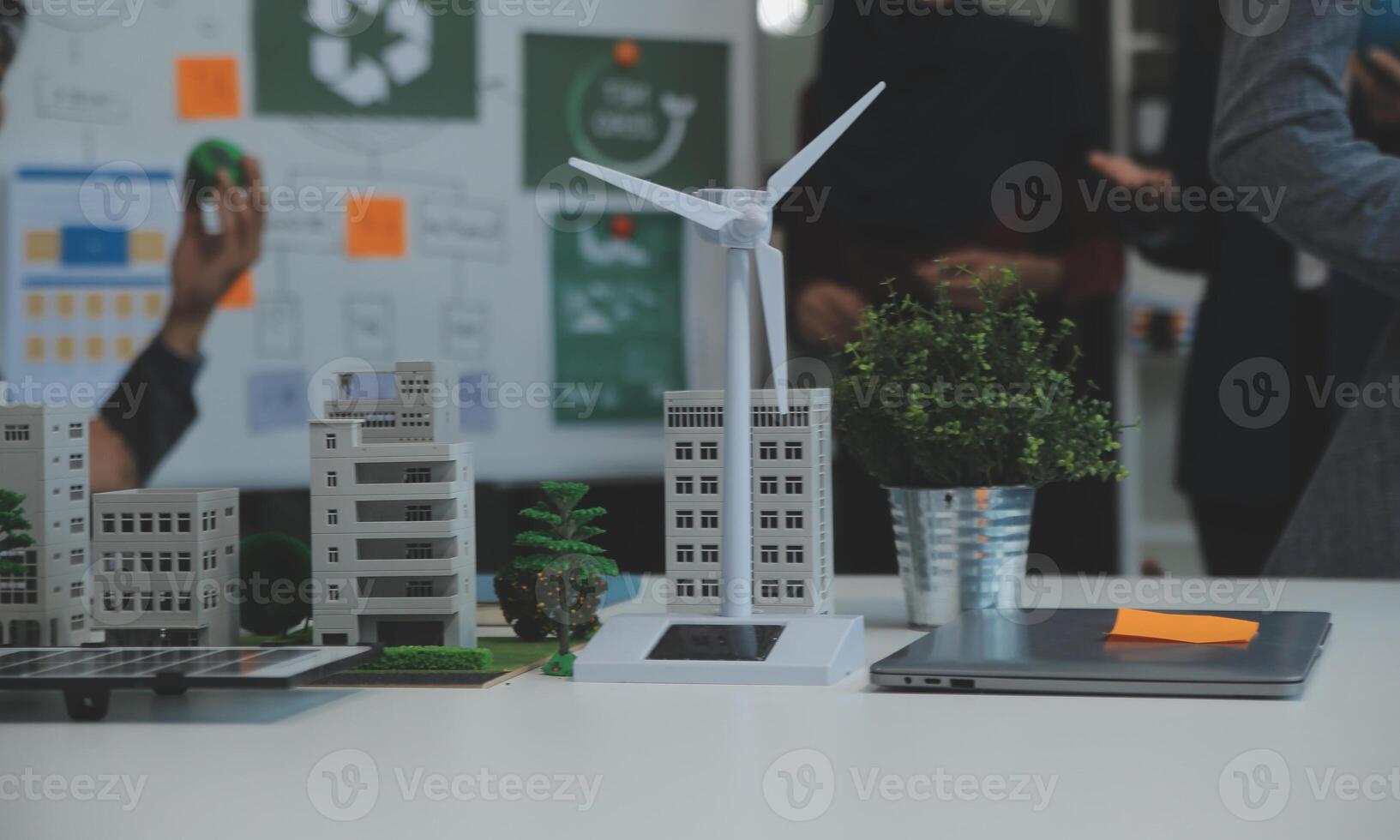 Business people having consultation about wind energy at company office. Business team discussing about windmill and alternative green energy. Executive meeting at modern office photo