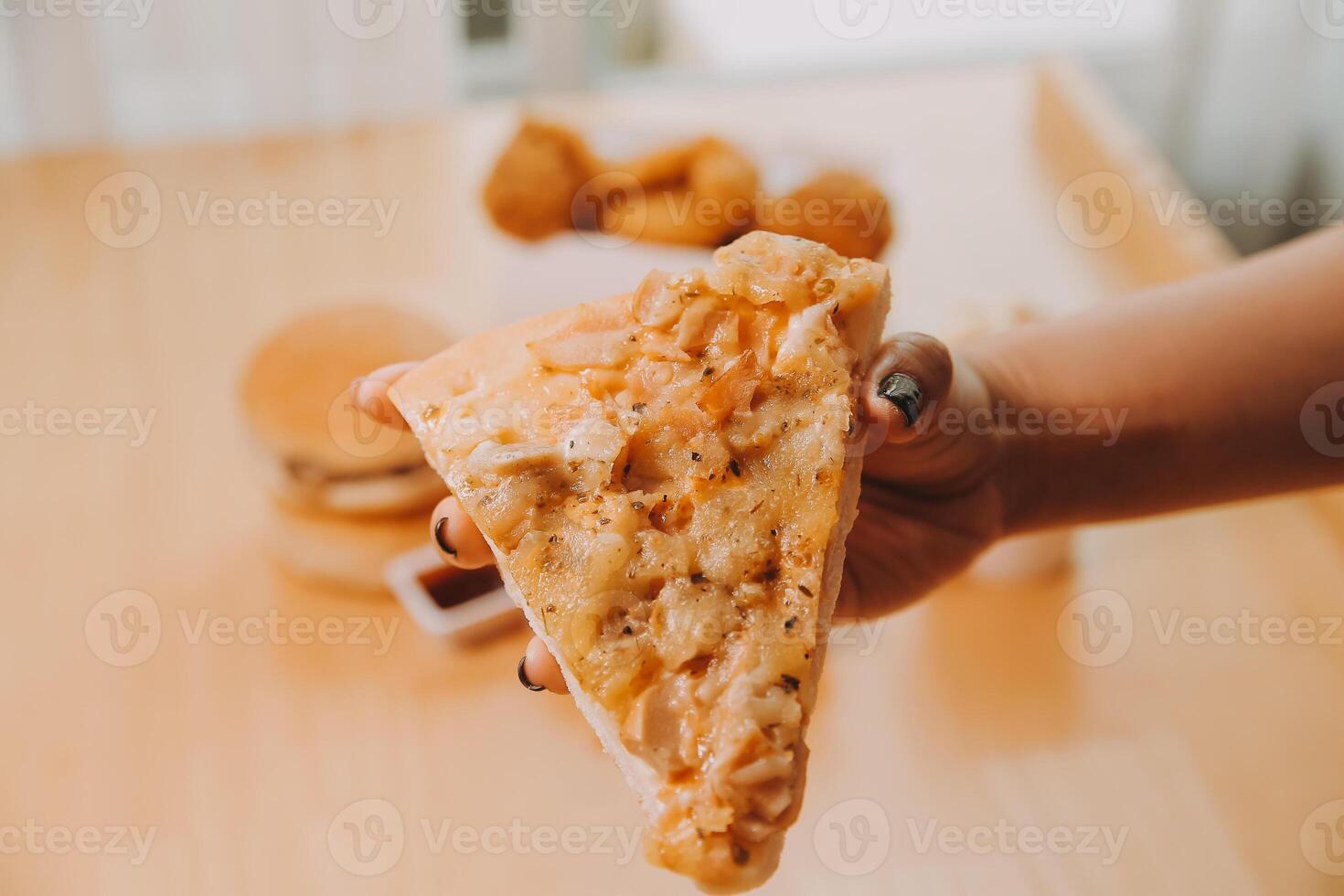 Cropped image of woman holding pizza slice at restaurant photo
