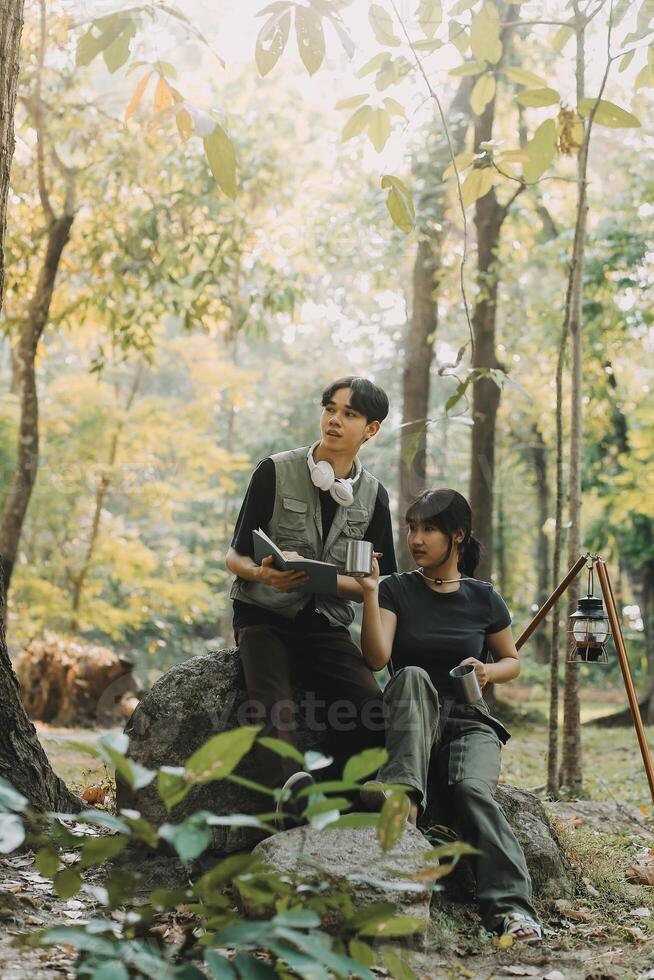 Asian couple sweet in tent inside on they camping trip, traveller relax and sleep togather in out door and camping trip photo