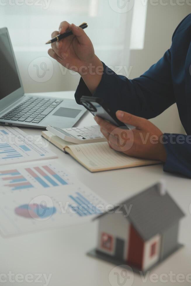 Businessmen holding pens, signing home titles with insurance, care about real estate services and the idea of real estate agents offering interest in installments to their customers. photo
