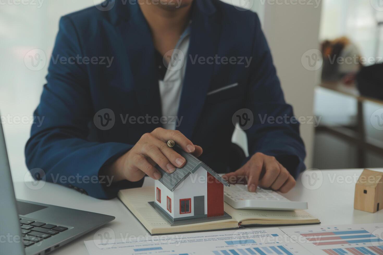 Businessmen holding pens, signing home titles with insurance, care about real estate services and the idea of real estate agents offering interest in installments to their customers. photo