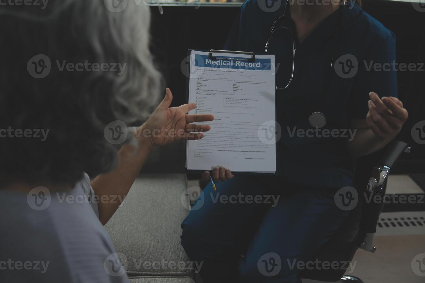 Female caregiver doing regular check-up of senior woman in her home. photo