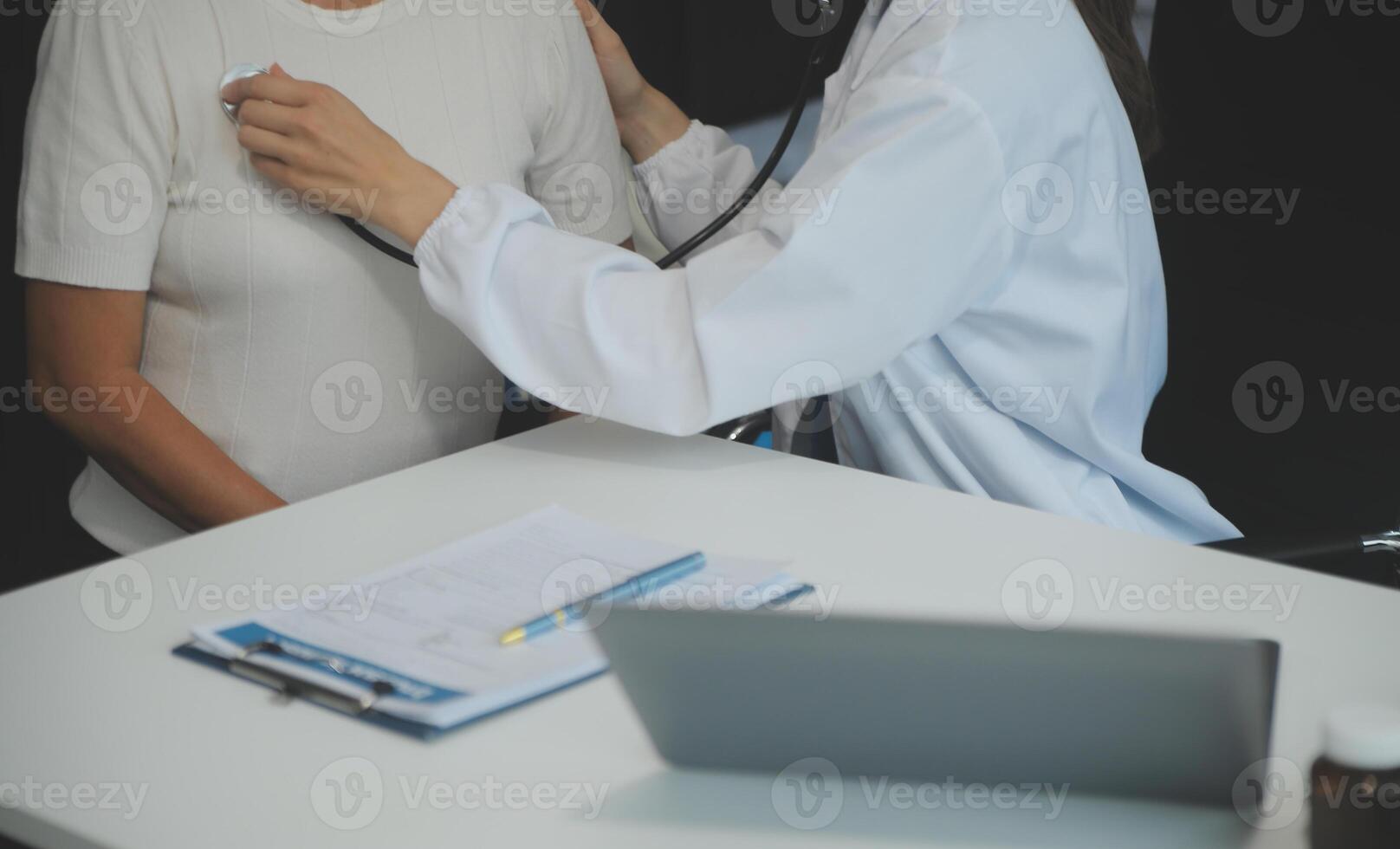 Doctor using sphygmomanometer with stethoscope checking blood pressure to a patient in the hospital. photo