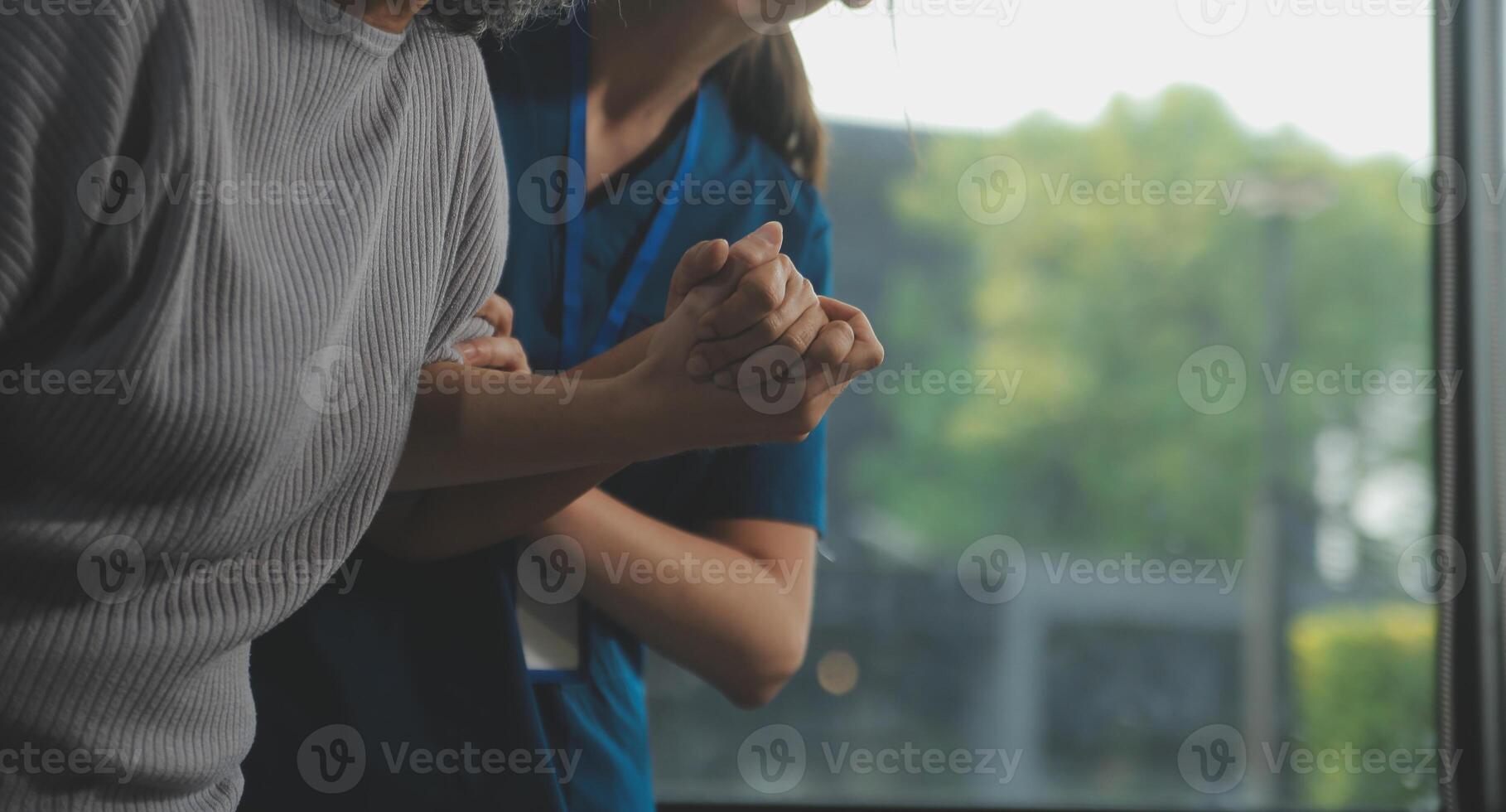 Female caregiver doing regular check-up of senior woman in her home. photo