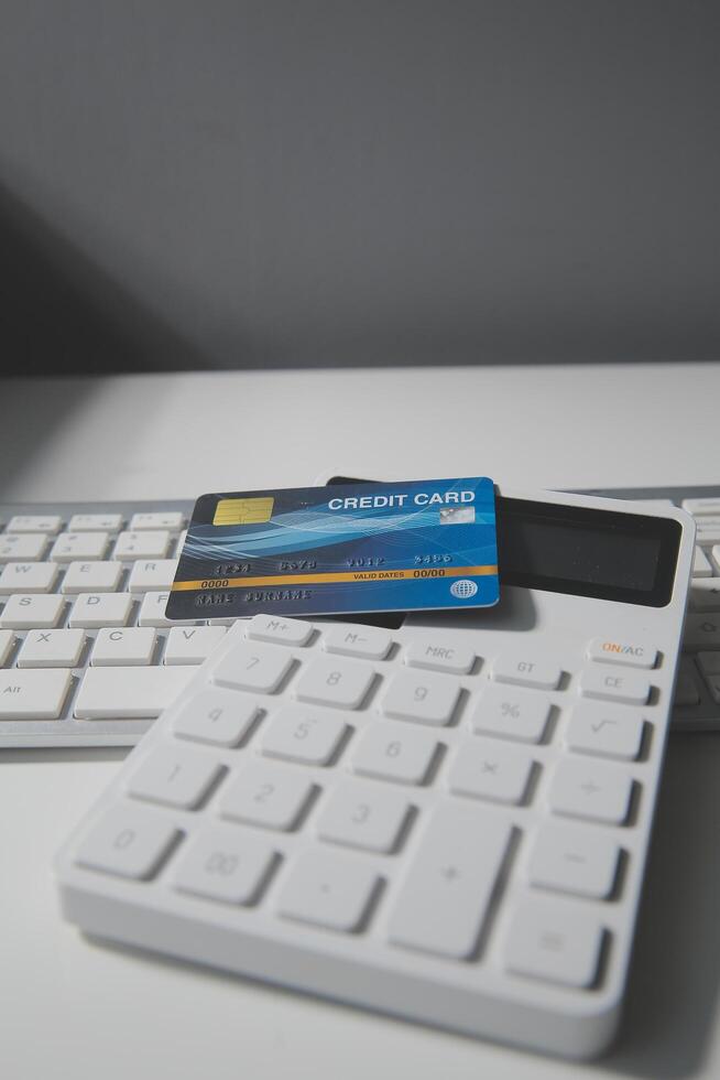 Calculator on a dark background, plastic cards and banknotes photo