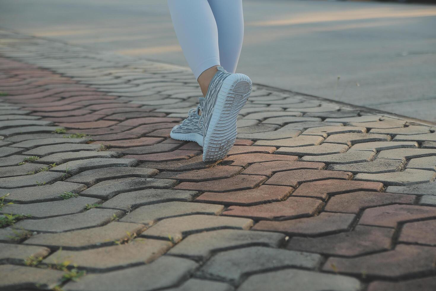 Young fitness woman runner stretching legs before run on city photo