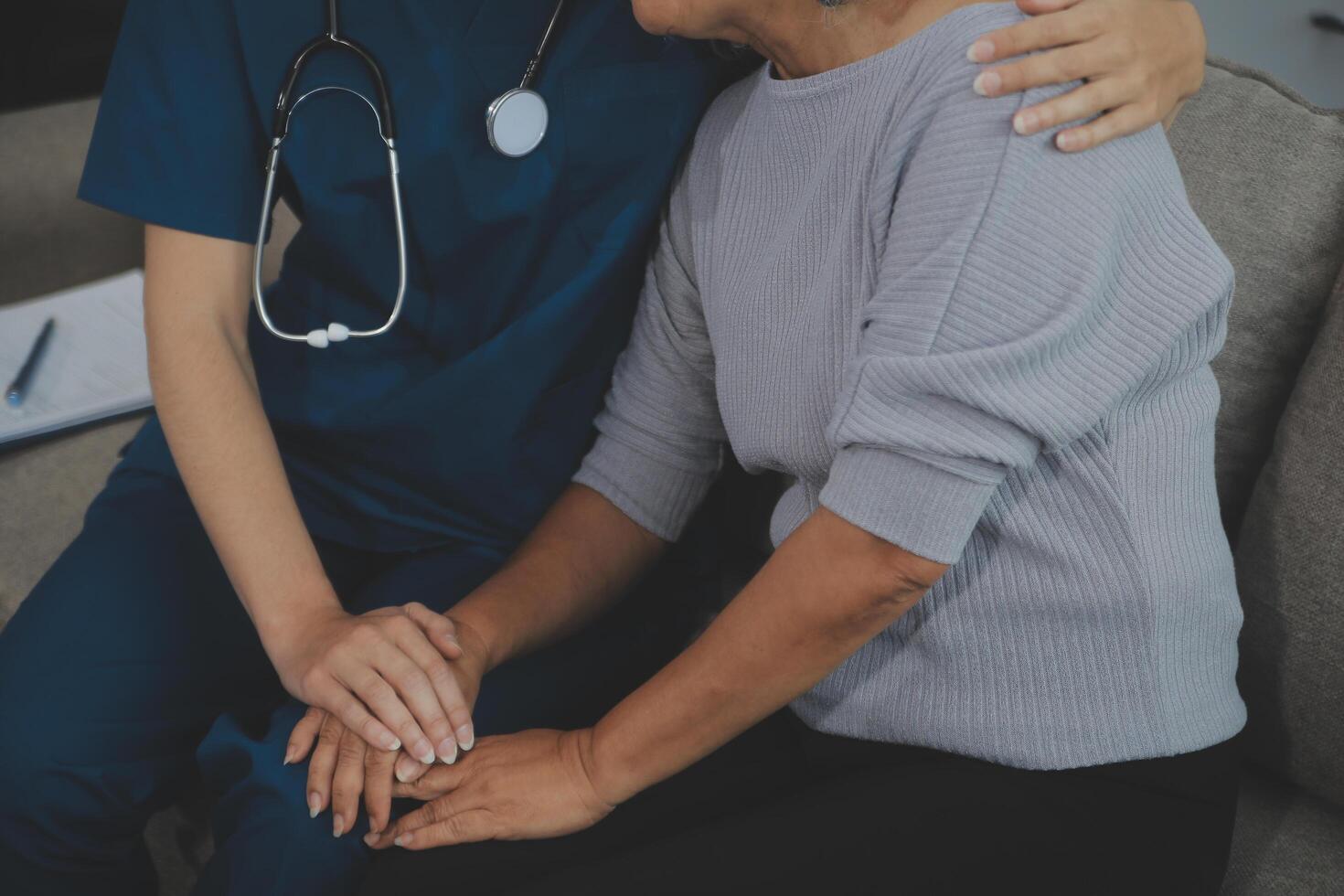 Female caregiver doing regular check-up of senior woman in her home. photo