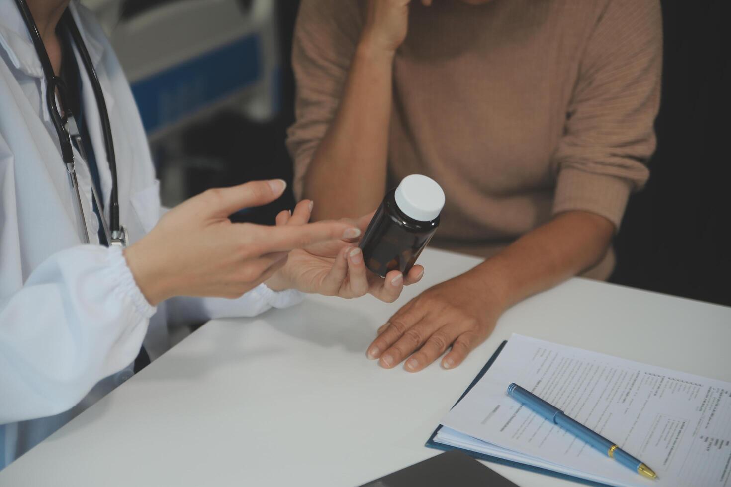 Smiling woman doctor prescribing medicine giving vitamins bottle to happy senior grandmother patient sit on sofa during medical healthcare visit, older people pharmacy medication treatment concept photo