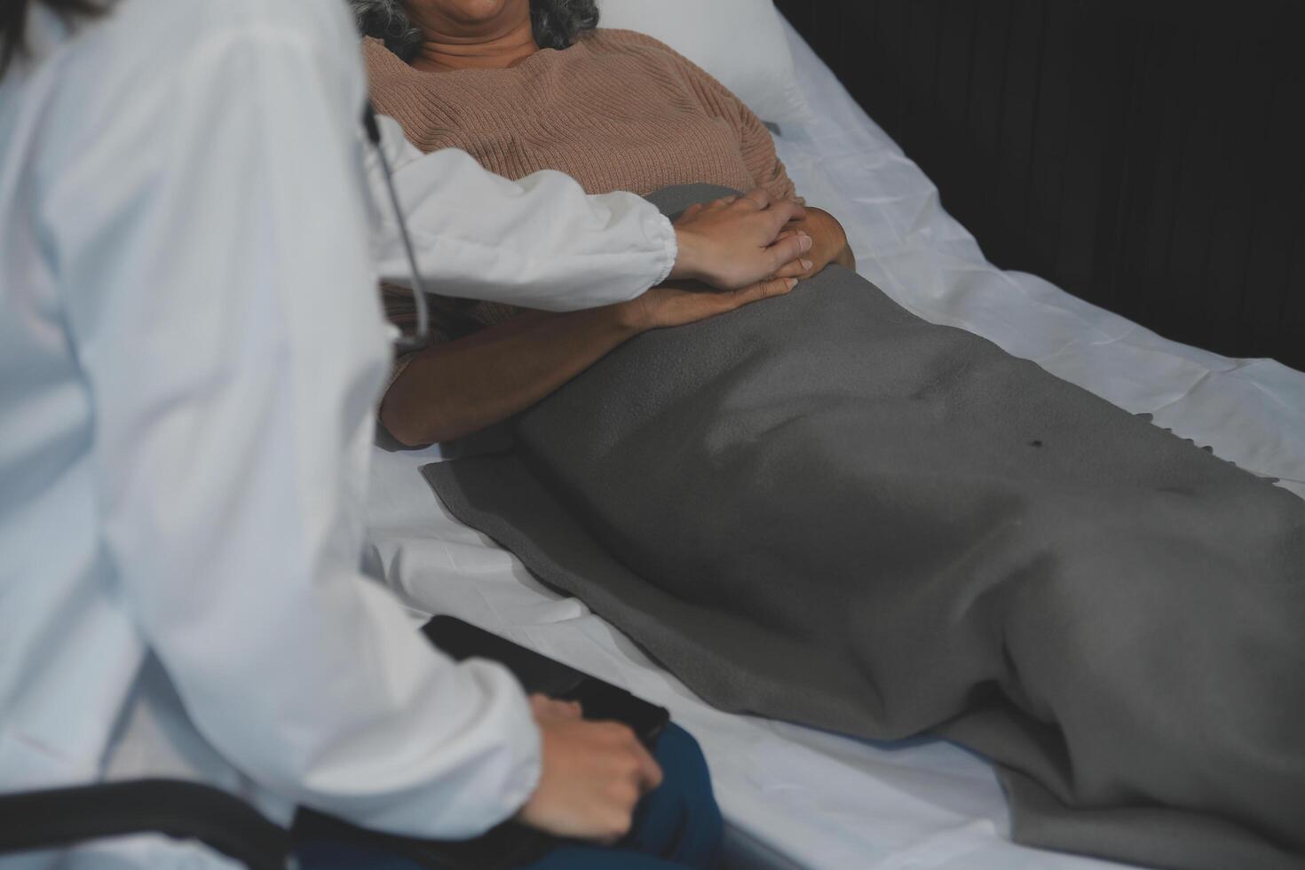 Cropped shot of a female nurse hold her senior patient's hand. Giving Support. Doctor helping old patient with Alzheimer's disease. Female carer holding hands of senior man photo