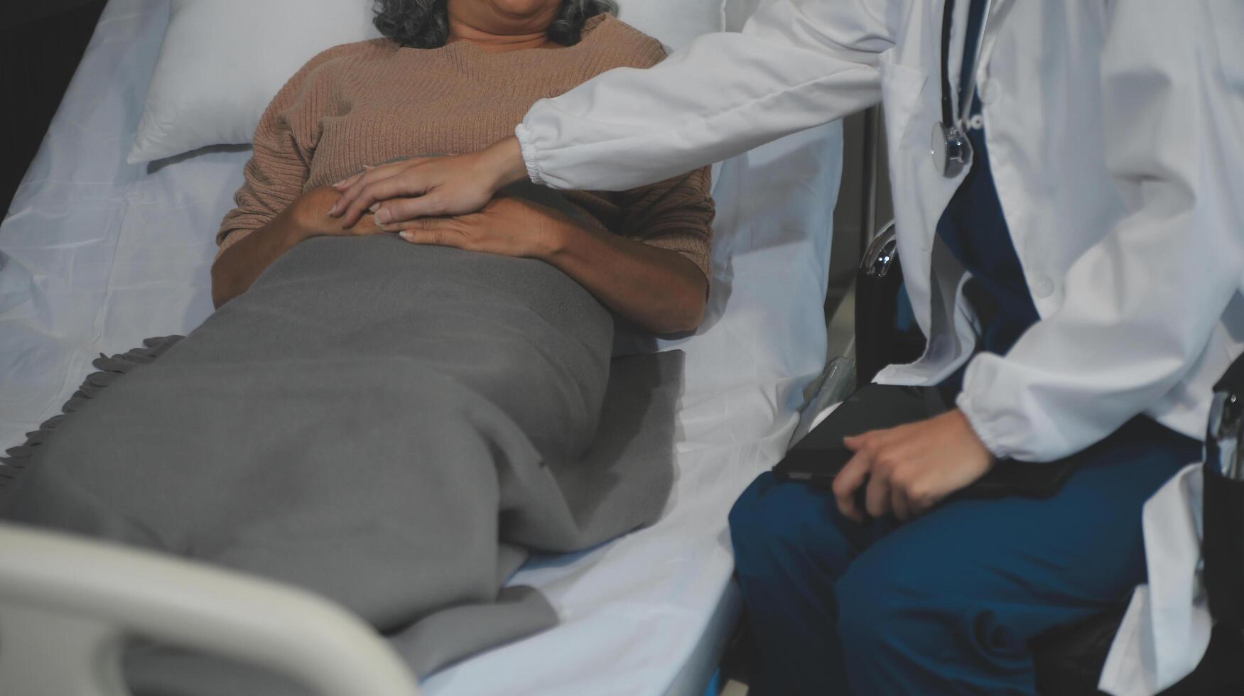Cropped shot of a female nurse hold her senior patient's hand. Giving Support. Doctor helping old patient with Alzheimer's disease. Female carer holding hands of senior man photo