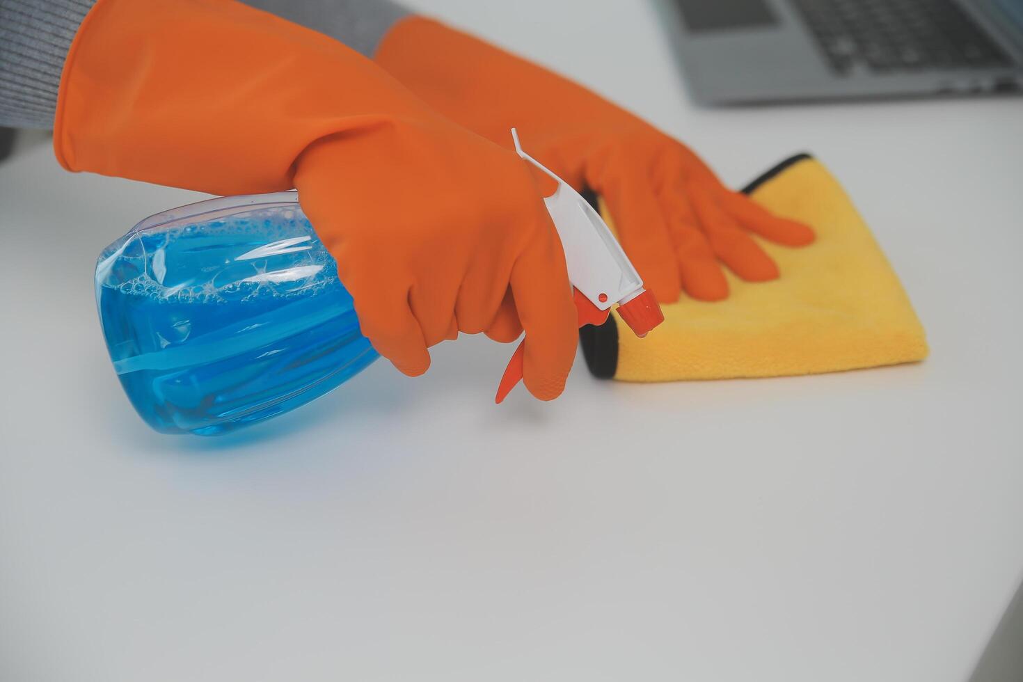 Woman cleaning table using rag and diffuser at home. photo