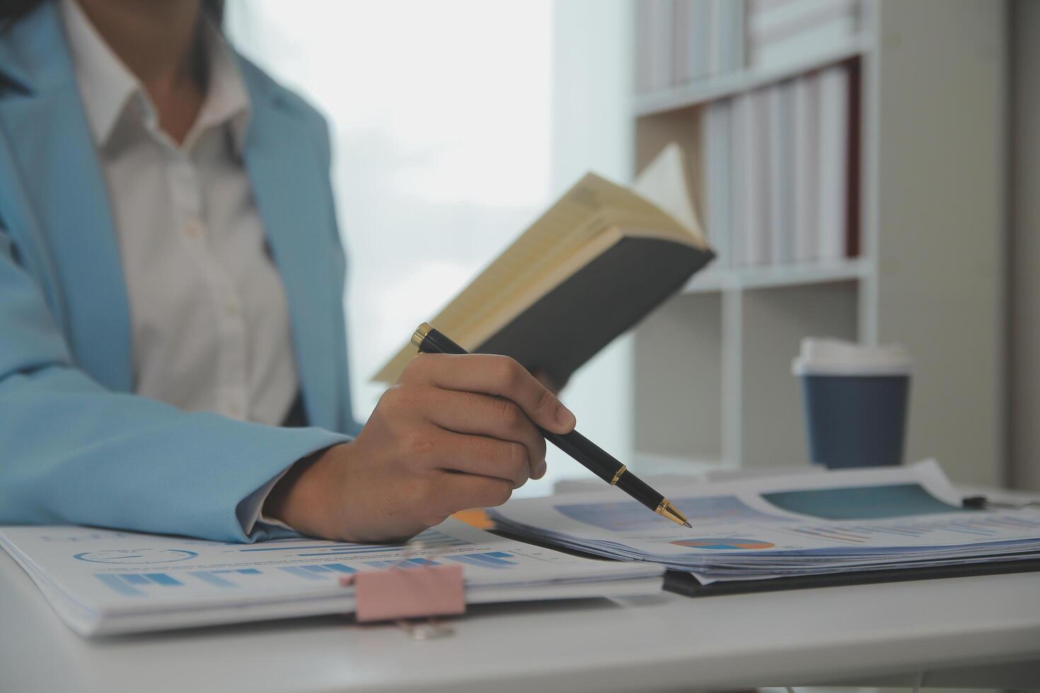 Charming Young asian businesswoman sitting on laptop computer in the office, making report calculating balance Internal Revenue Service checking document. photo