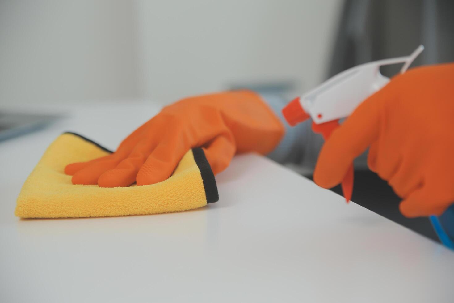 Woman cleaning table using rag and diffuser at home. photo