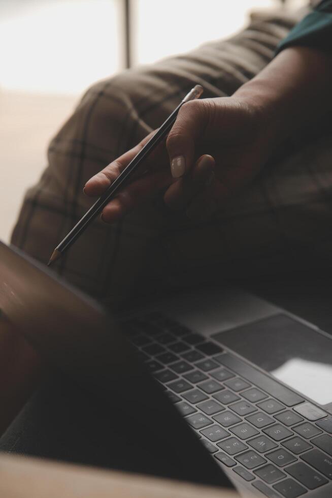 Distracted from work worried young woman sitting on couch with laptop, thinking of problems. Pensive unmotivated lady looking at window, feeling lack of energy, doing remote freelance tasks at home. photo