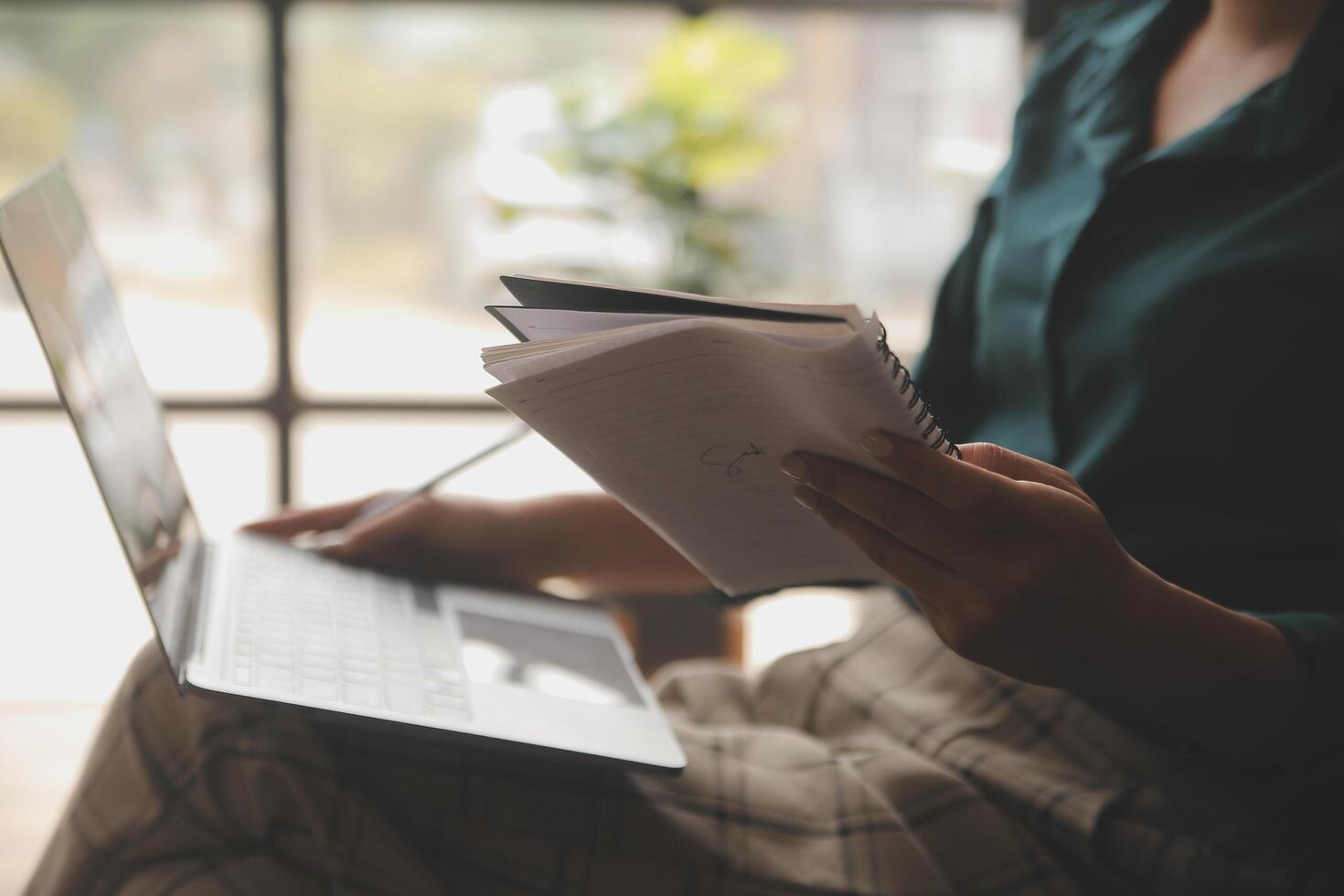 Distracted from work worried young woman sitting on couch with laptop, thinking of problems. Pensive unmotivated lady looking at window, feeling lack of energy, doing remote freelance tasks at home. photo