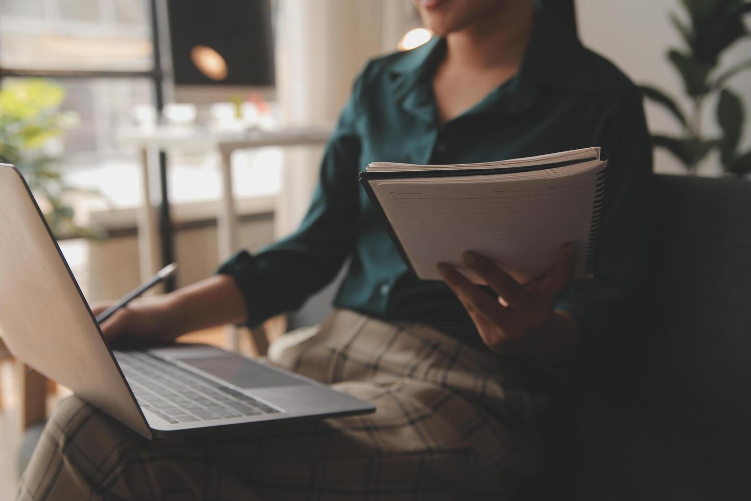 Distracted from work worried young woman sitting on couch with laptop, thinking of problems. Pensive unmotivated lady looking at window, feeling lack of energy, doing remote freelance tasks at home. photo
