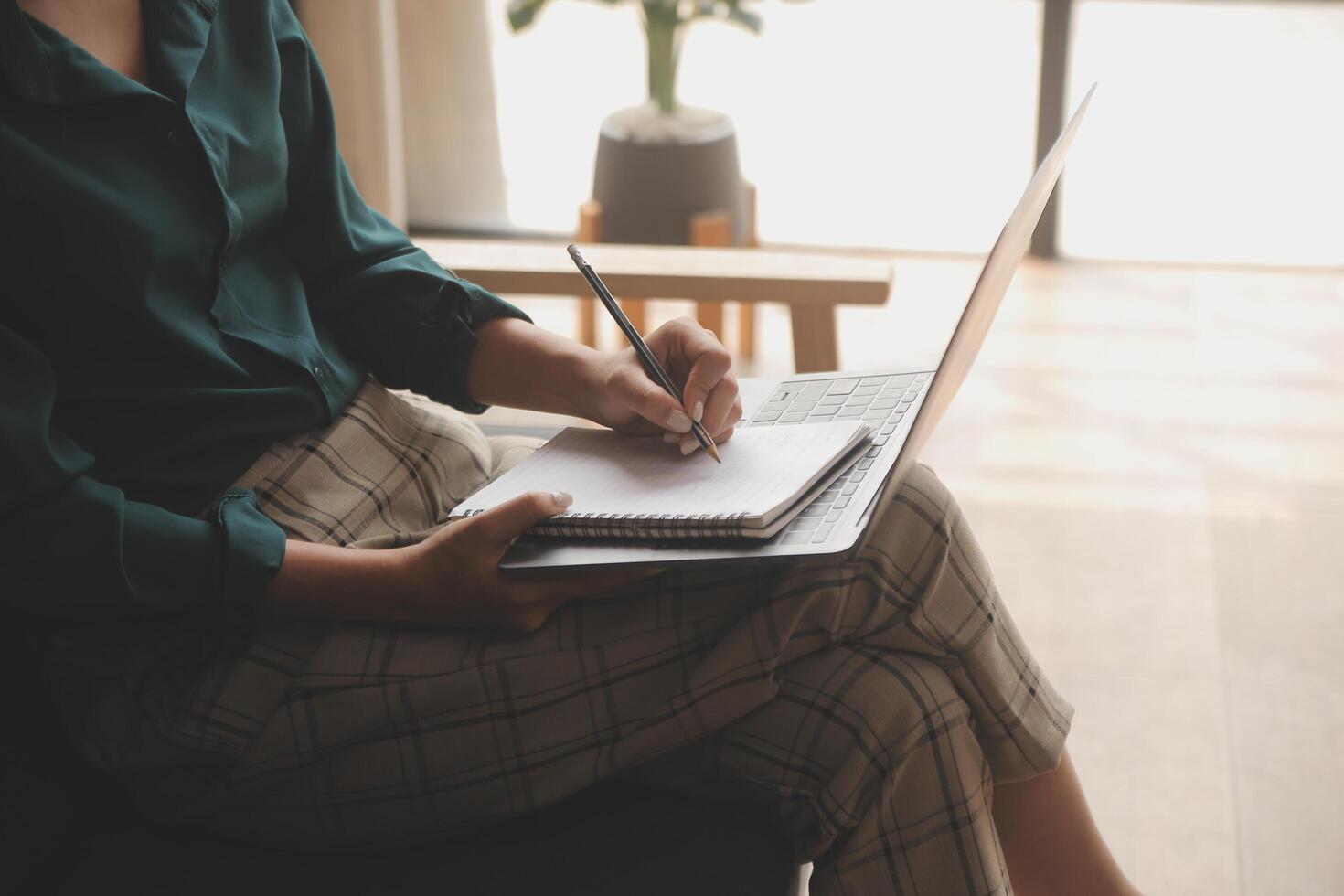 Distracted from work worried young woman sitting on couch with laptop, thinking of problems. Pensive unmotivated lady looking at window, feeling lack of energy, doing remote freelance tasks at home. photo