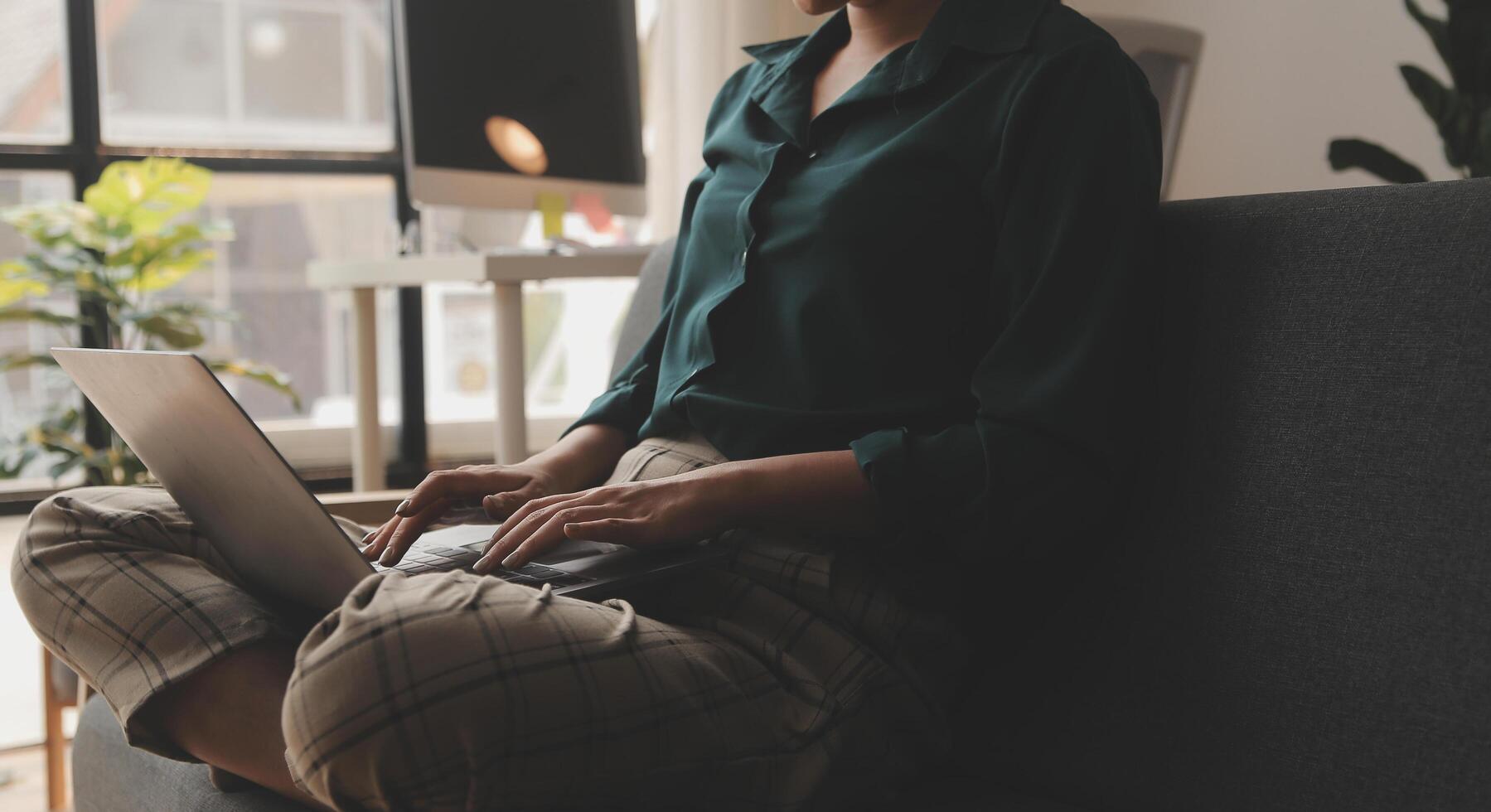 Distracted from work worried young woman sitting on couch with laptop, thinking of problems. Pensive unmotivated lady looking at window, feeling lack of energy, doing remote freelance tasks at home. photo