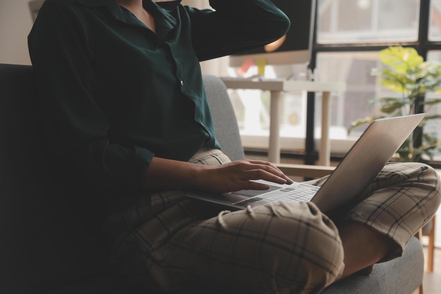 Distracted from work worried young woman sitting on couch with laptop, thinking of problems. Pensive unmotivated lady looking at window, feeling lack of energy, doing remote freelance tasks at home. photo