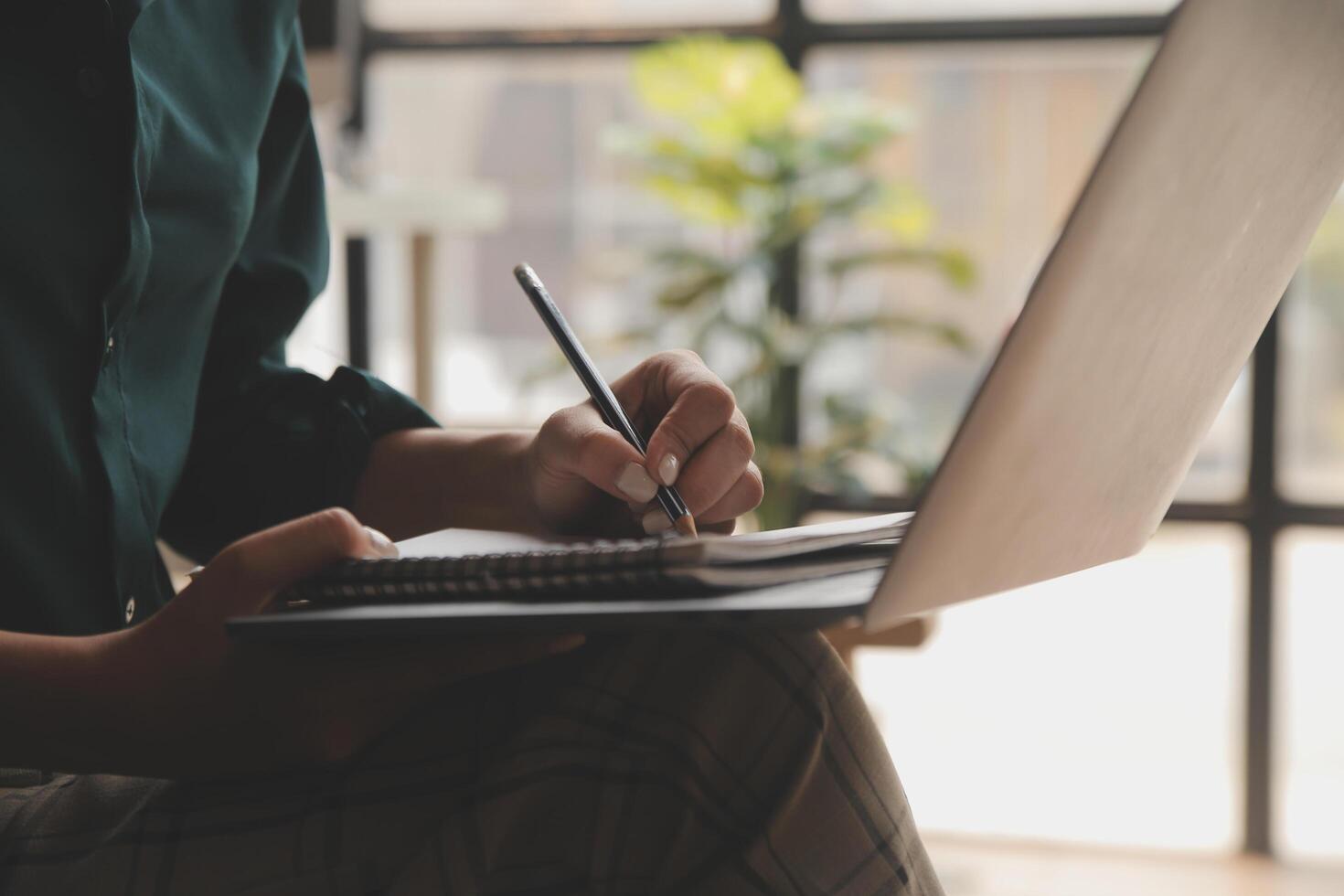 Distracted from work worried young woman sitting on couch with laptop, thinking of problems. Pensive unmotivated lady looking at window, feeling lack of energy, doing remote freelance tasks at home. photo