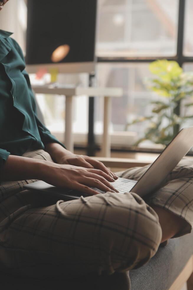 Distracted from work worried young woman sitting on couch with laptop, thinking of problems. Pensive unmotivated lady looking at window, feeling lack of energy, doing remote freelance tasks at home. photo