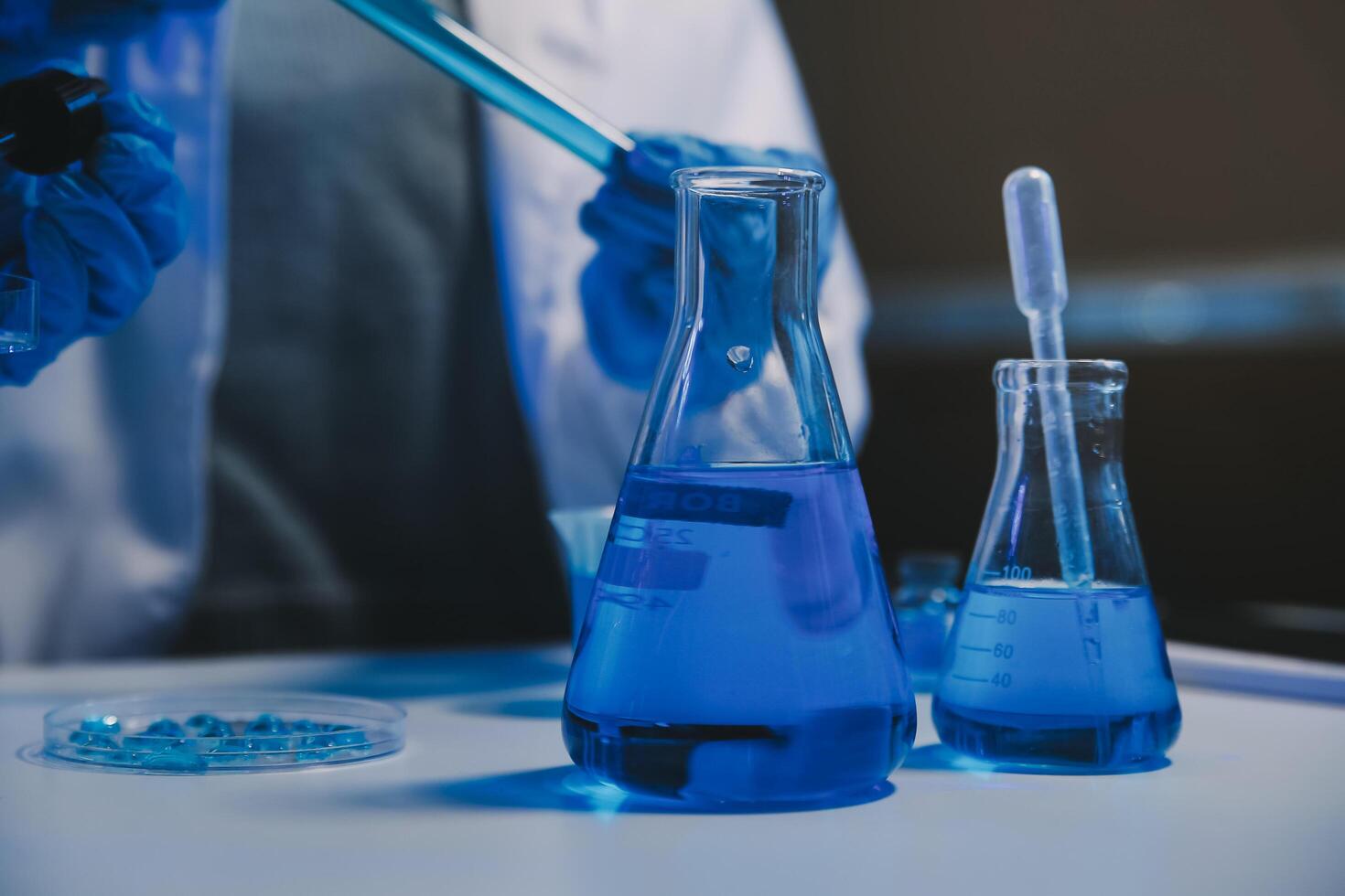 chemist,scientist hand dropping chemical liquid into test tube, science research and development concept photo