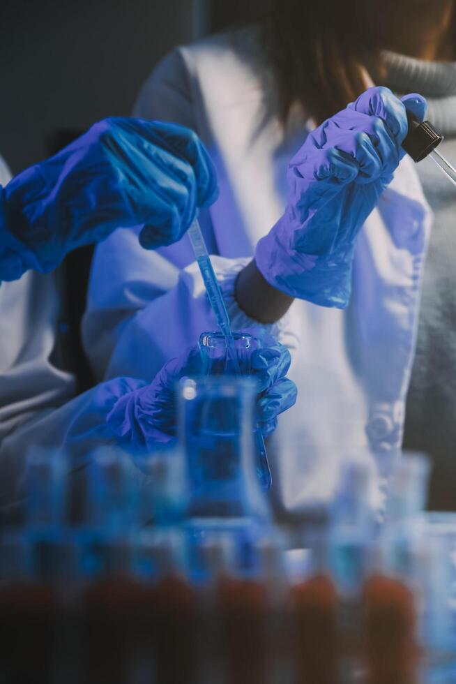 chemist,scientist hand dropping chemical liquid into test tube, science research and development concept photo