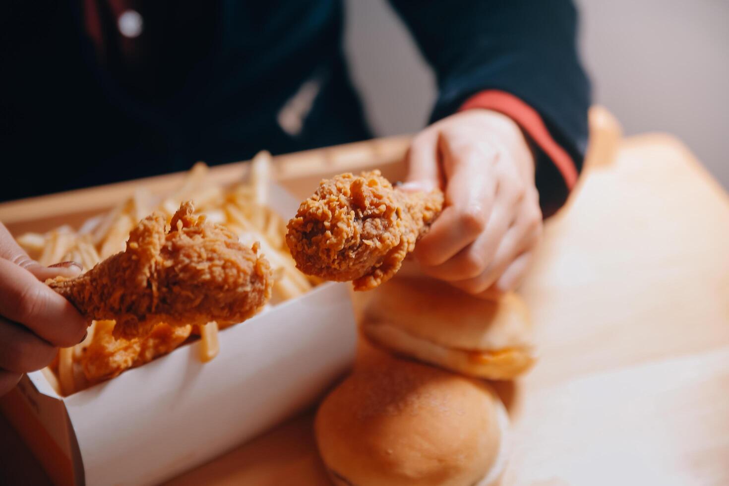 close up focus woman hand hold fried chicken for eat,girl with fast food concept photo
