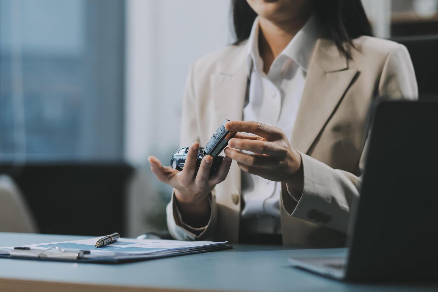 Business car rental company service, Close up hand of agent dealer giving, holding car key to customer renter, new owner after signed rental, purchase contract in document, vehicle sales agreement. photo