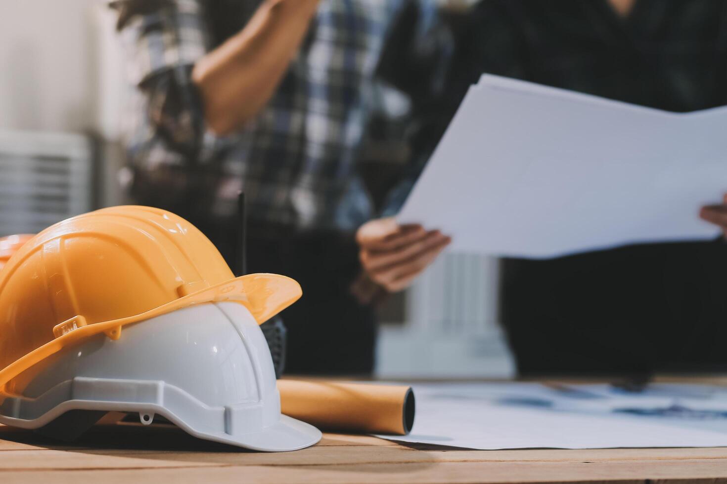 Asian young female architect discussing with japanese male building manager contractor for quality control site inspection and at house construction site in room under renovation project. photo
