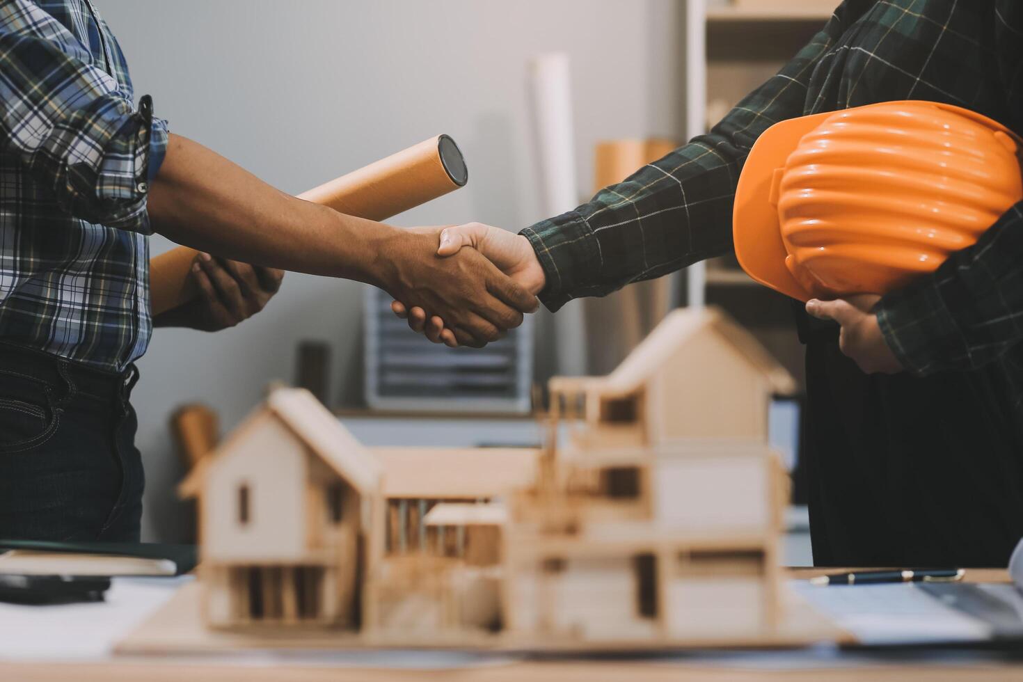 Architect and construction engineer holding hands while working for teamwork and cooperation concept after completing an agreement at construction site, office, close-up image photo