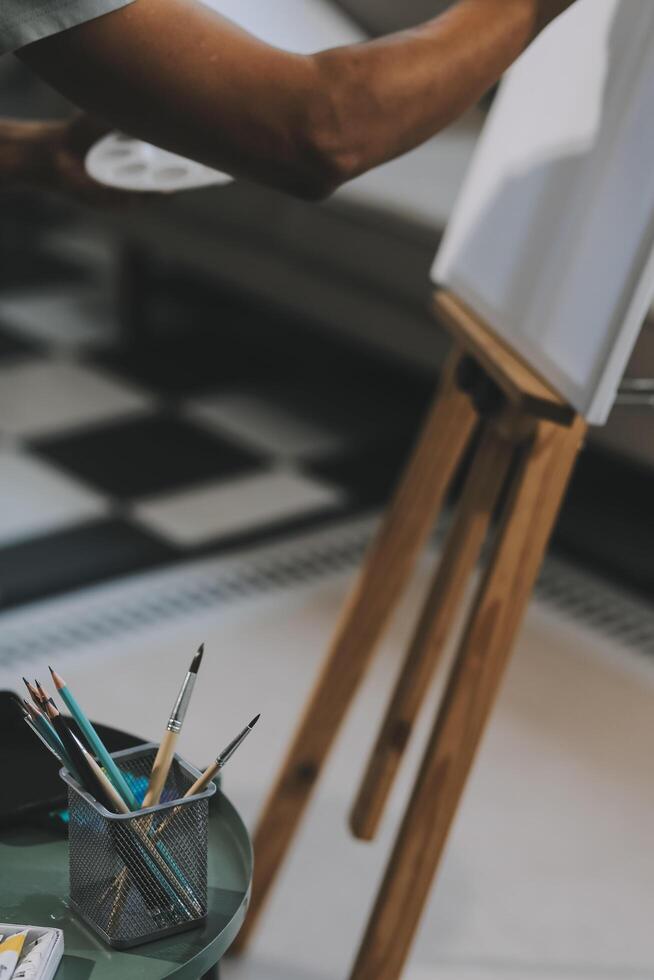 Young male artist painting picture in studio photo