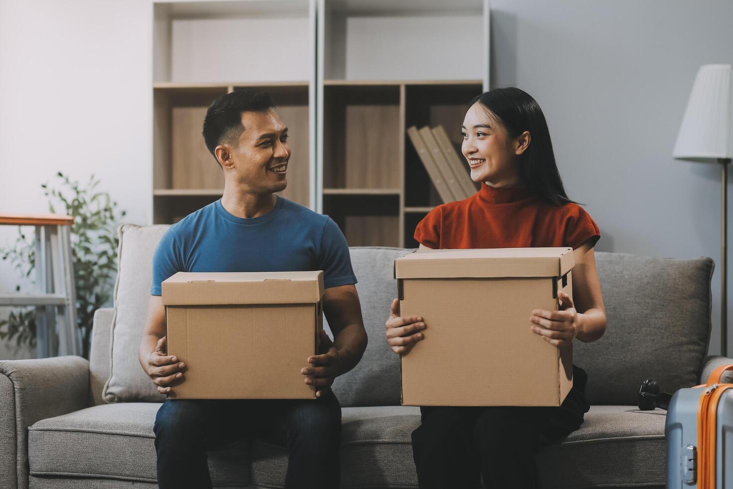 joven Pareja con grande cajas Moviente dentro un nuevo casa, nuevo Departamento para pareja, joven hombre y mujer Ayudar a levantar cajas y organizar cosas para el nuevo hogar, Moviente casa. foto