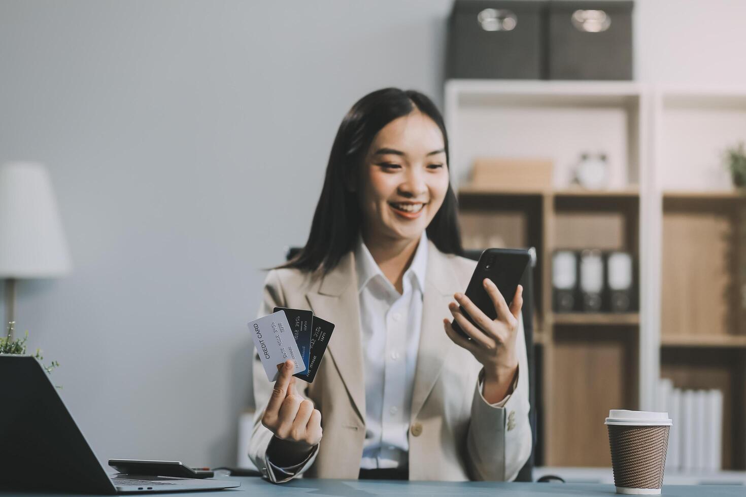 Asian woman holding credit card and using laptop computer for shopping online in website at home, e-commerce, internet banking, Technology and money transfer. Shopping and online payment concept. photo