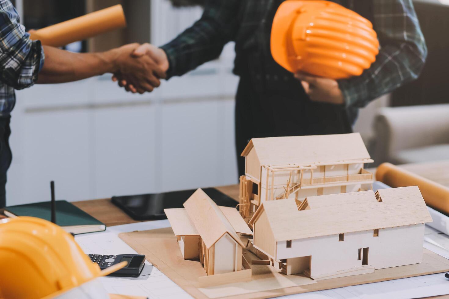 Architect and construction engineer holding hands while working for teamwork and cooperation concept after completing an agreement at construction site, office, close-up image photo