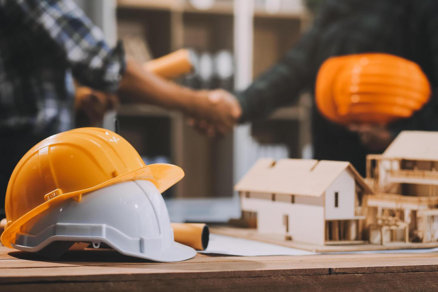 Architect and construction engineer holding hands while working for teamwork and cooperation concept after completing an agreement at construction site, office, close-up image photo