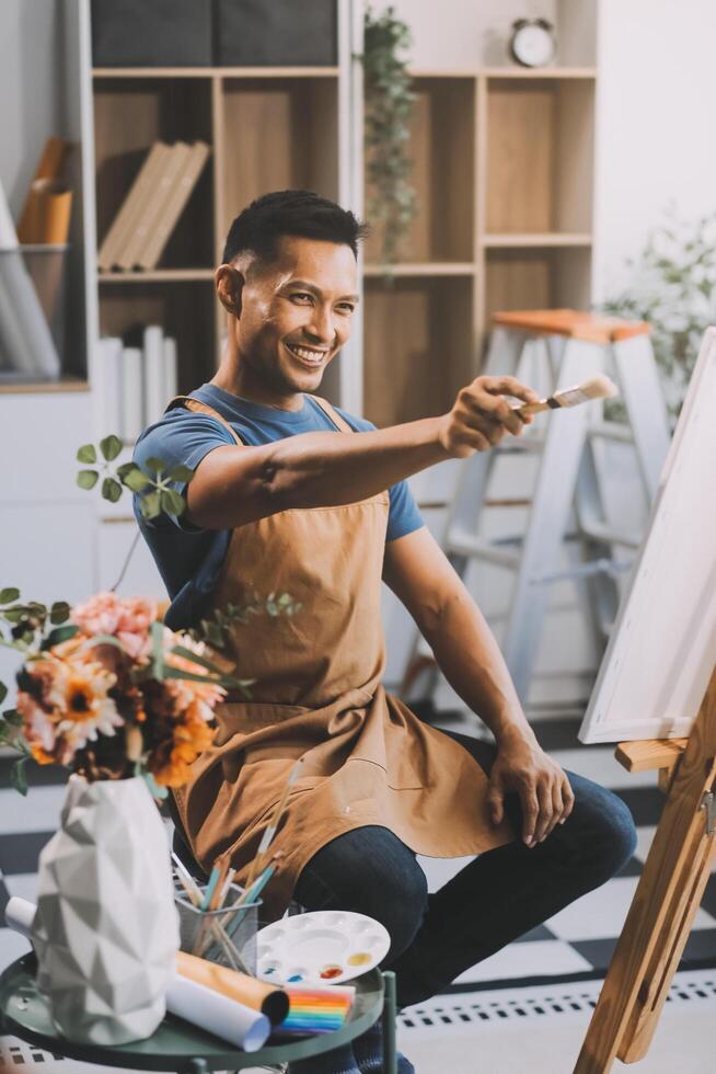 Young male artist painting picture in studio photo