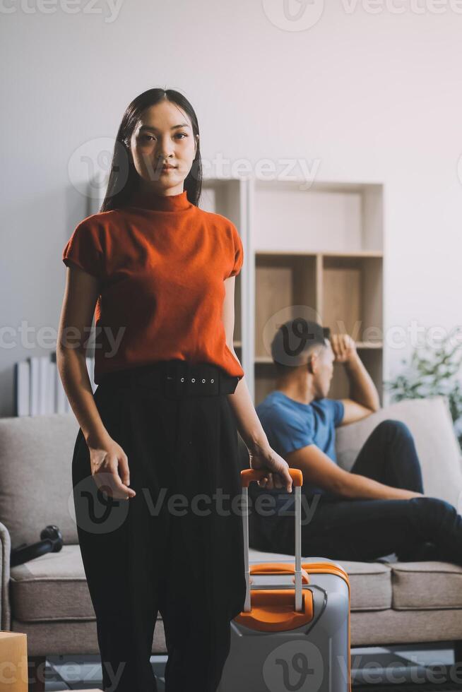 Family couple ignoring each other after a quarrel. Two people turn away and don't talk to each other. Angry young man and woman sitting back to back, with arms crossed on the sofa in the living room photo